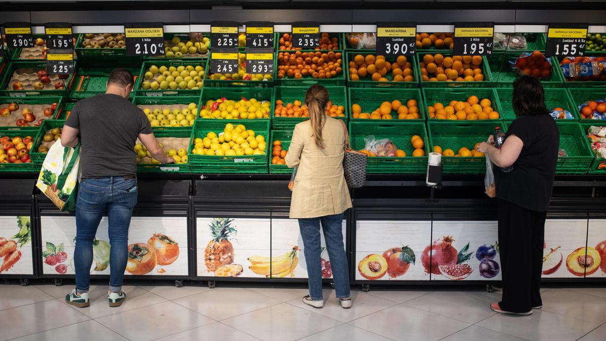 Varias personas realizan la compra en un supermercado de Madrid.