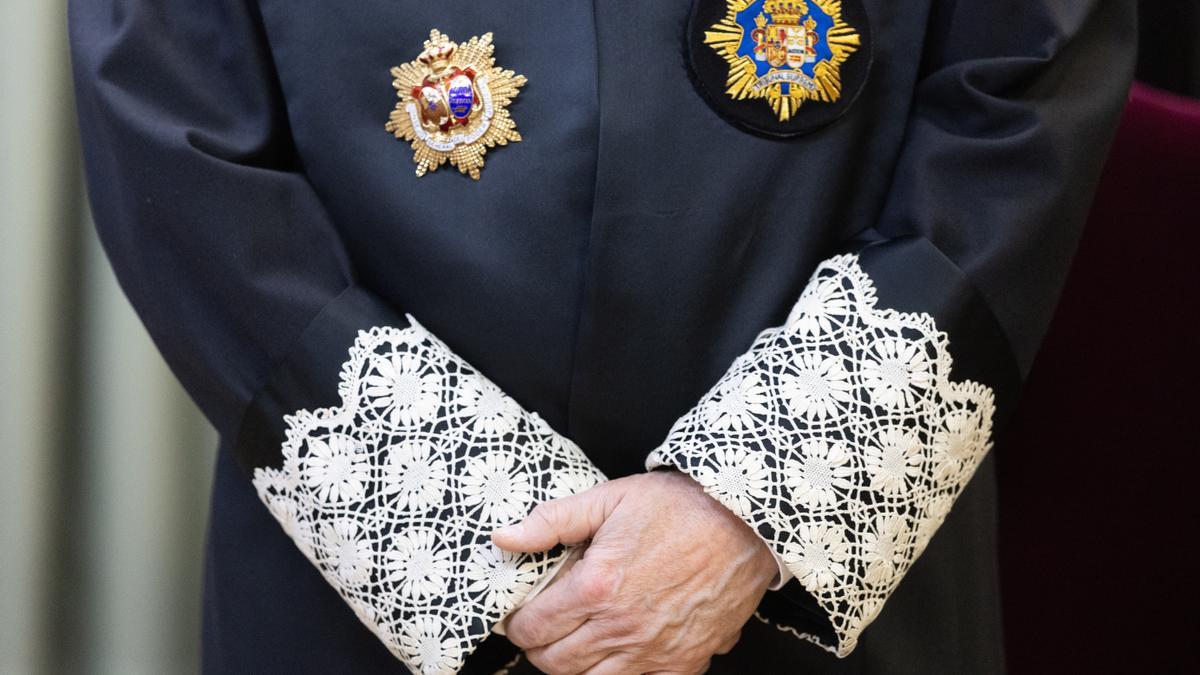 Un juez vestido con su toga cruza las manos durante una toma de posesión.