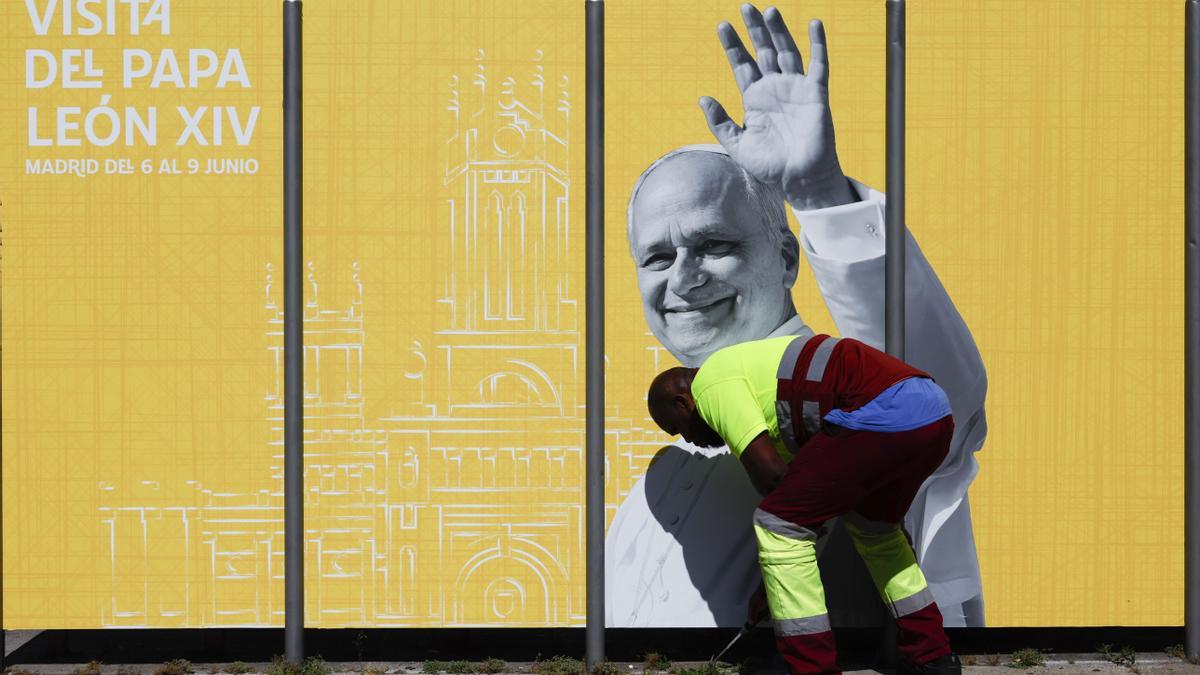 Un operario coloca una valla con motivo de la próxima visita del papa León XIV a España.