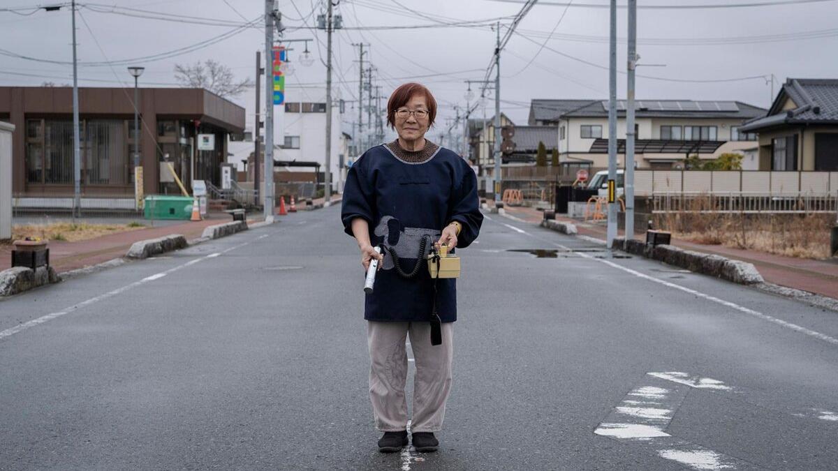 Tomoko Kobayashi, propietaria de un riokan y miembro de una red de ciudadanos que miden la radiactividad. Sostiene un contador Geiger en la calle principal de Odaka.