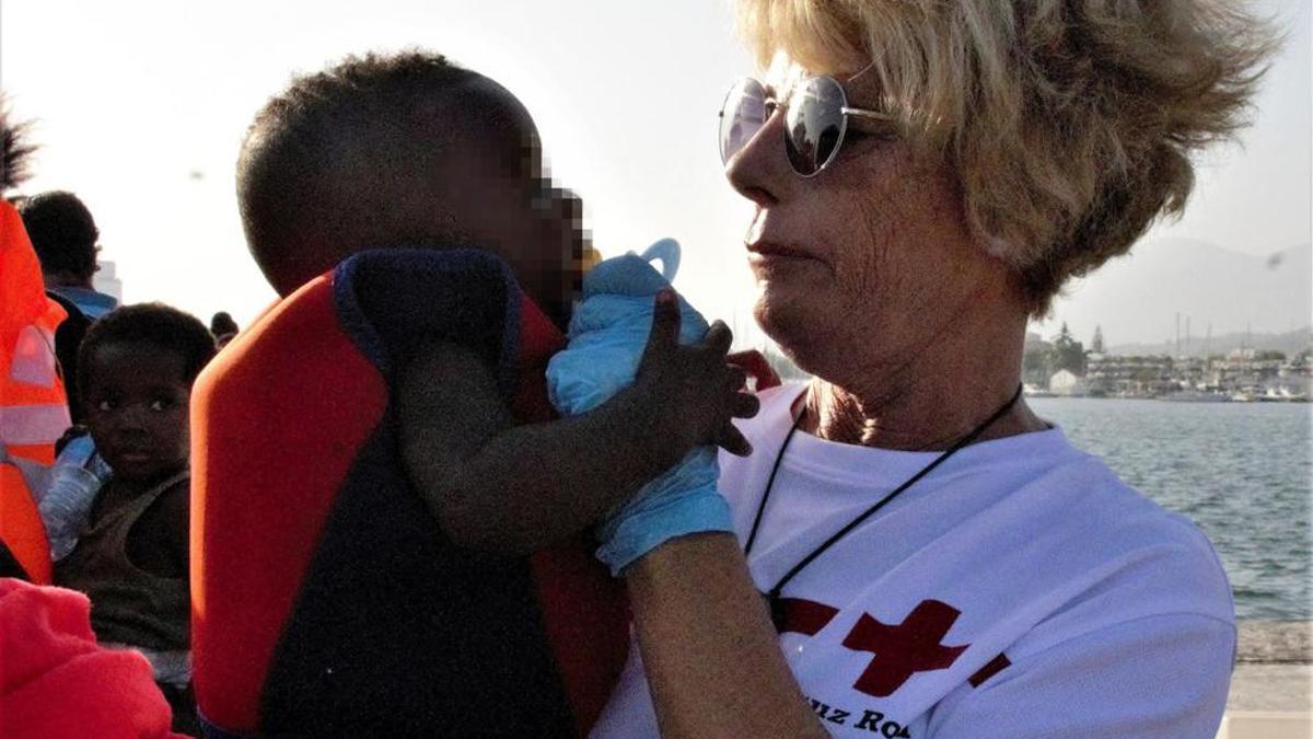 Un miembro de la Cruz Roja con uno de los menores que ha sido rescatado, con 240 inmigrantes mas, cuando navegaban en 5 pateras en las cercanías de la isla de Alborán.