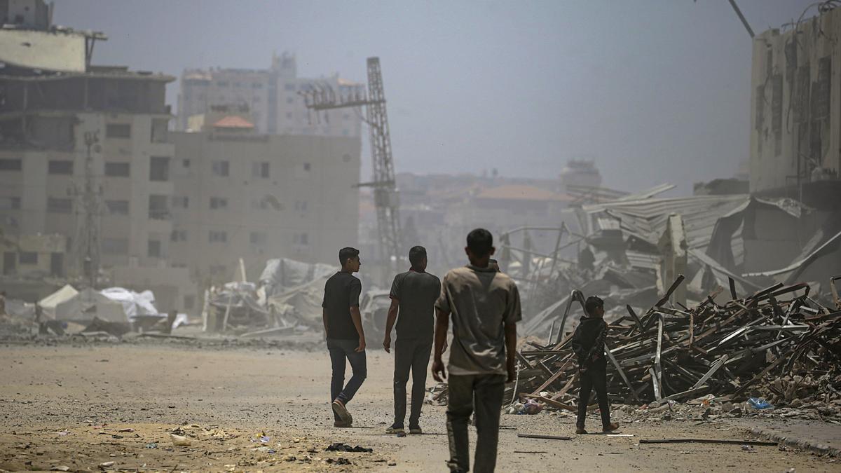 Desplazados internos palestinos inspeccionan un edificio destruido tras un ataque aéreo israelí al oeste de la ciudad de Gaza, en la Franja de Gaza.