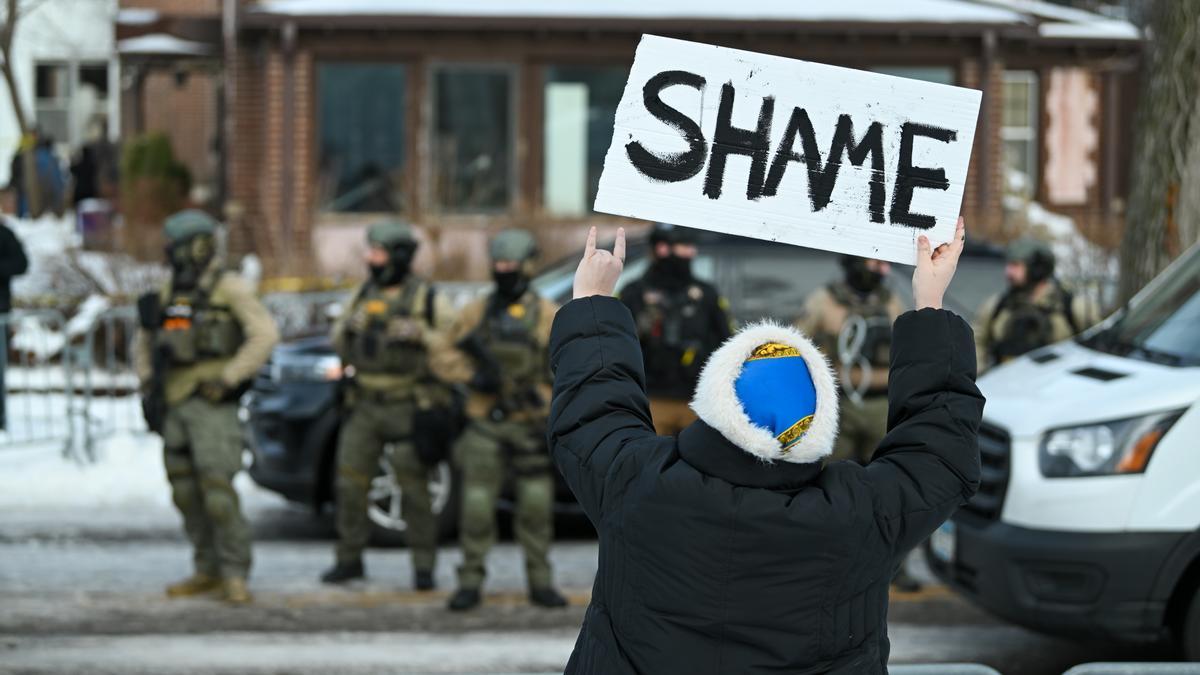 Un manifestante sostiene un cartel en el lugar donde una mujer fue asesinada a tiros por un agente del Servicio de Inmigración y Control de Aduanas (ICE) en Minneapolis, Minnesota, EE. UU., el 7 de enero de 2026.