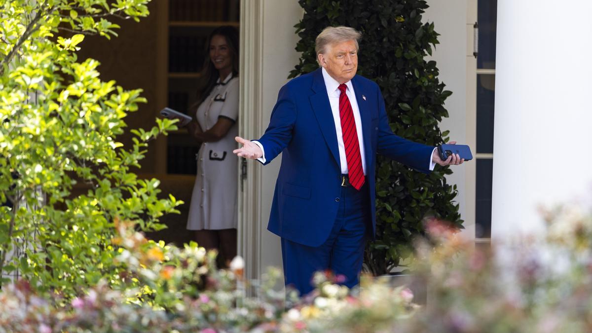 El presidente estadounidense, Donald Trump, saluda a los trabajadores que pavimentan el Jardín de las Rosas al salir de la Casa Blanca.