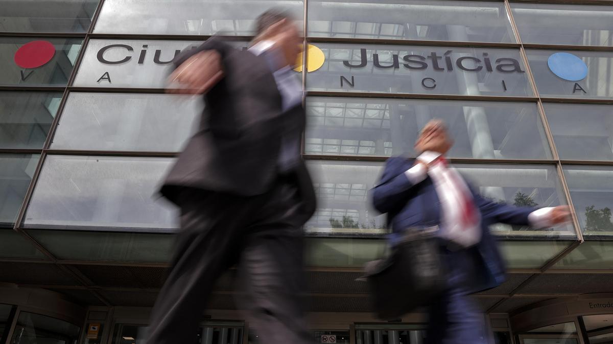 Dos personas salen de la Ciudad de la Justicia de Valencia.