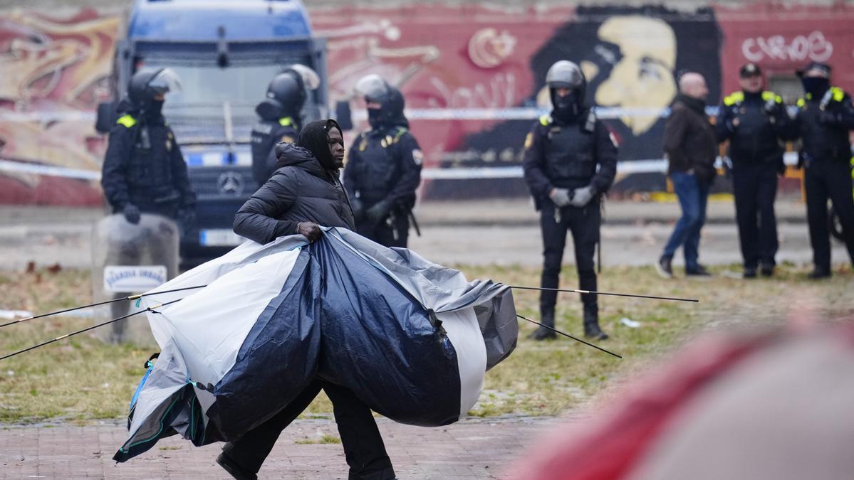 Uno de los migrantes acampados en una plaza junto al antiguo instituto B9 de Badalona abandona el lugar.