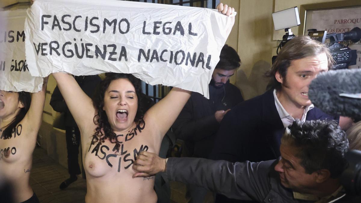 Un hombre toca el pecho a una de los dos activistas de Femen que protestan en la misa por Franco.