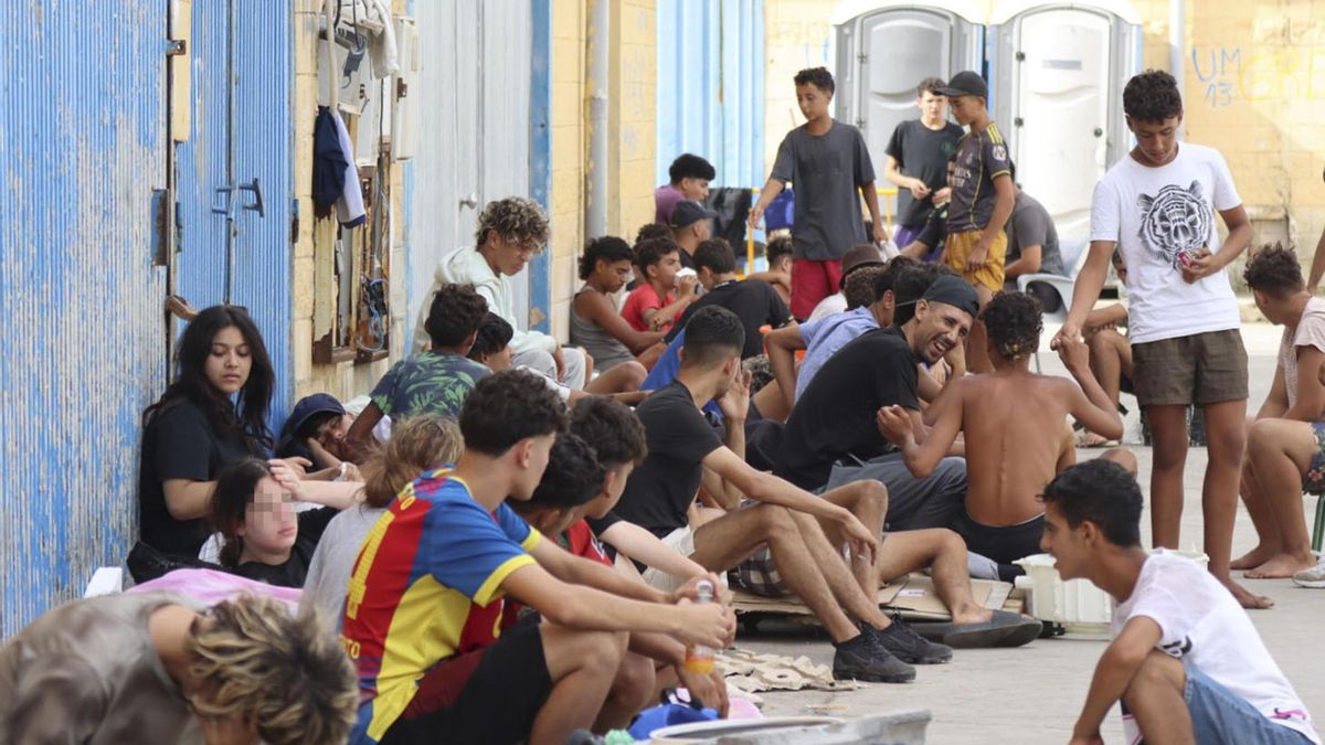 Cientos de inmigrantes marroquíes descansan en las calles de Ceuta, este lunes.