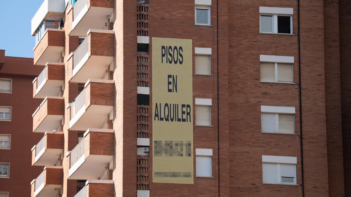 Cartel de alquiler de viviendas en la fachada de un edificio en Barcelona, Cataluña.