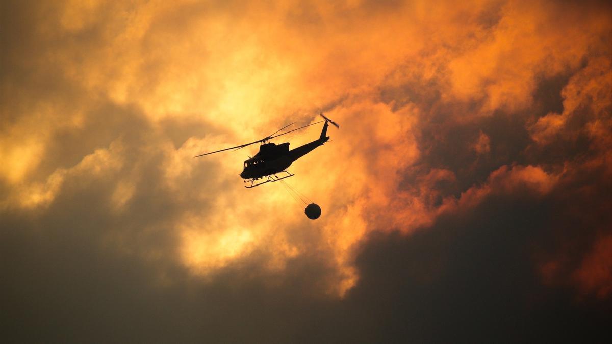 Un helicóptero recoge agua para ayudar con las labores de extinción del incendio, a 26 de agosto de 2025, en Aguas Mestas, Lugo.