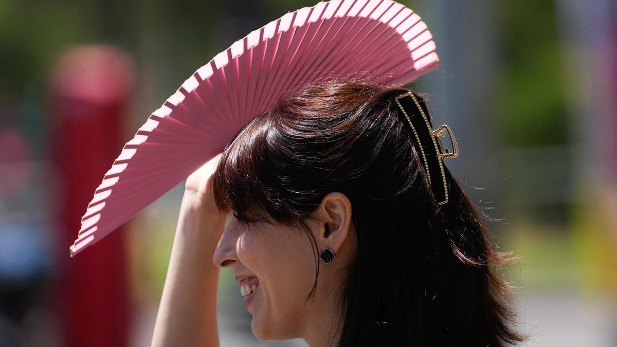 Una mujer se protege del sol en el centro de Barcelona.