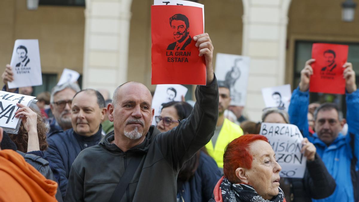 Varias personas muestran carteles del alcalde de Alicante, Luis Barcala, durante la concentración llevada a cabo este miércoles en la plaza del ayuntamiento de Alicante bajo el lema "Vivenda pública y social. Ni concesiones ni privilegios".