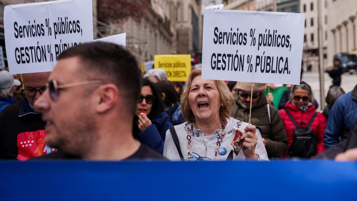 Varias personas con carteles durante una manifestación en defensa de los servicios públicos en Madrid.