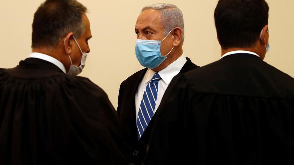 El primer ministro israelí, Benjamin Netanyahu con una máscarilla se encuentra dentro de la sala del tribunal el primer día de su juicio por presuntos delitos de corrupción.