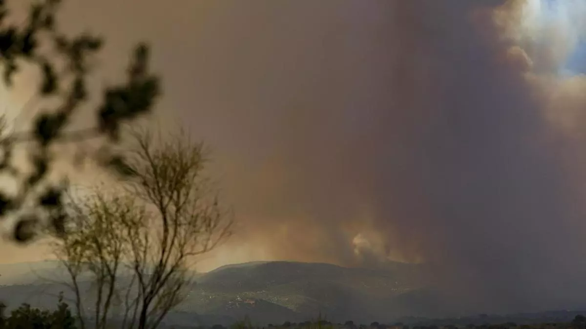 Columna de humo producida por el incendio que se mantiene activo en la localidad madrileña de Pelayos de la Presa.