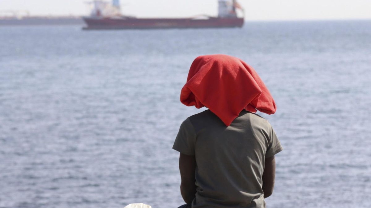 Una persona, sentada en la playa del Trampolín de Ceuta.