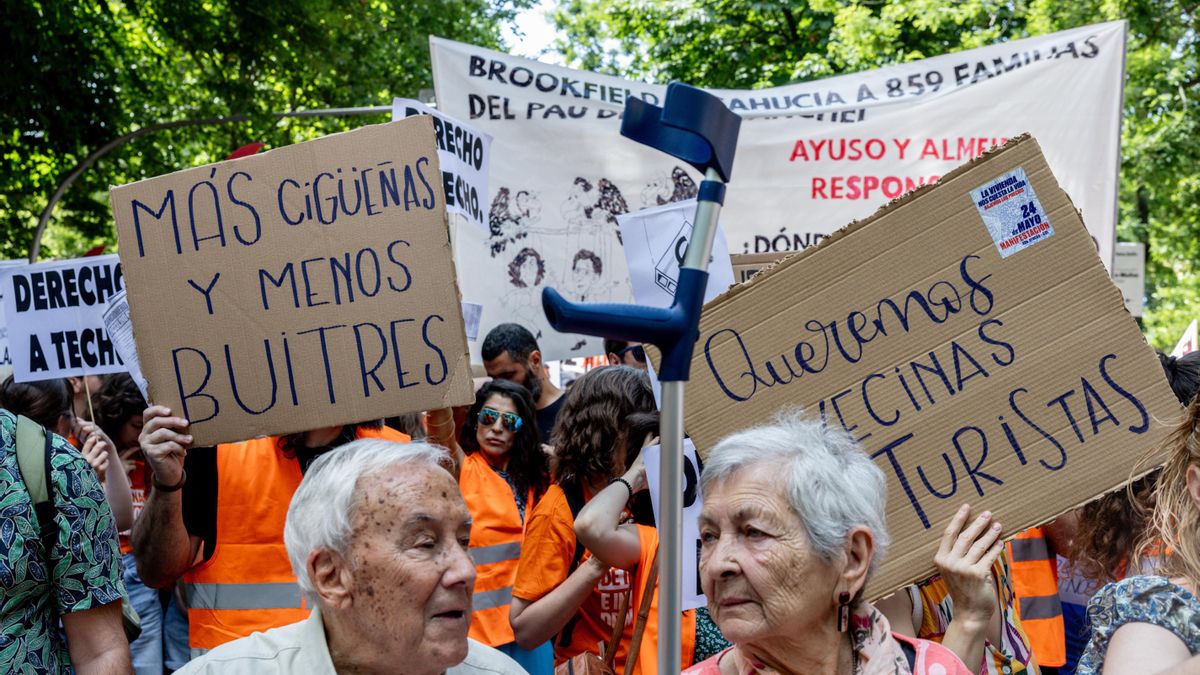 Manifestantes portan pancartas con lemas 'Más cigüeñas y menos buitres' y 'Queremos vecinas, no turistas' durante una manifestación en Madrid.