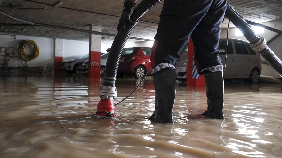 Una persona achica agua de un garaje en Gran Canaria trás la tormenta.