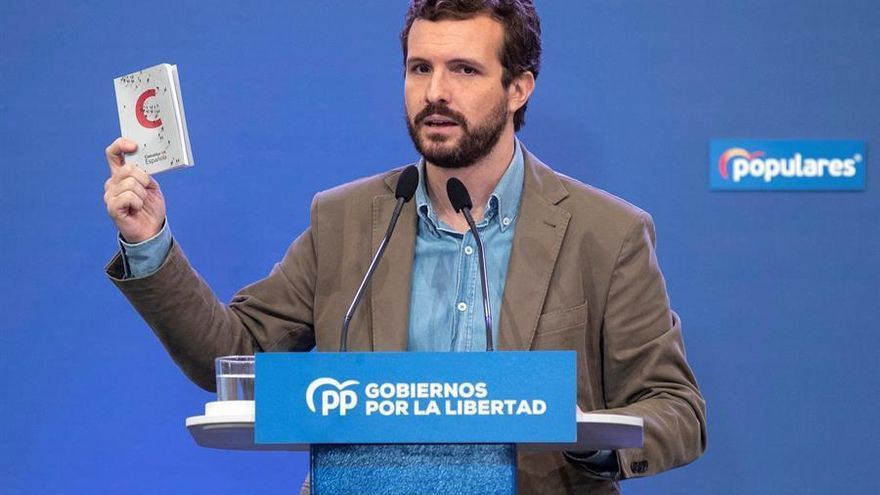 El presidente del PP Pablo Casado muestra un ejemplar de la constitución.