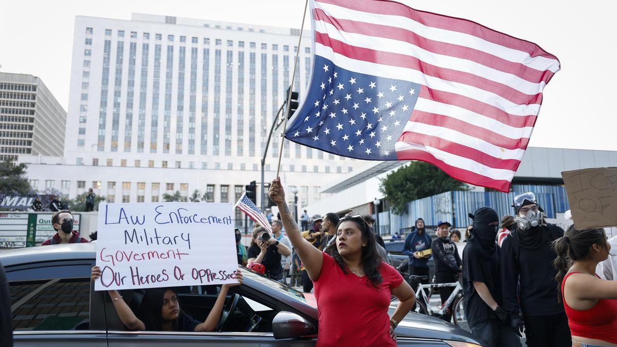 Una mujer ondea la bandera de Estados Unidos en las protestas de Los Ángeles