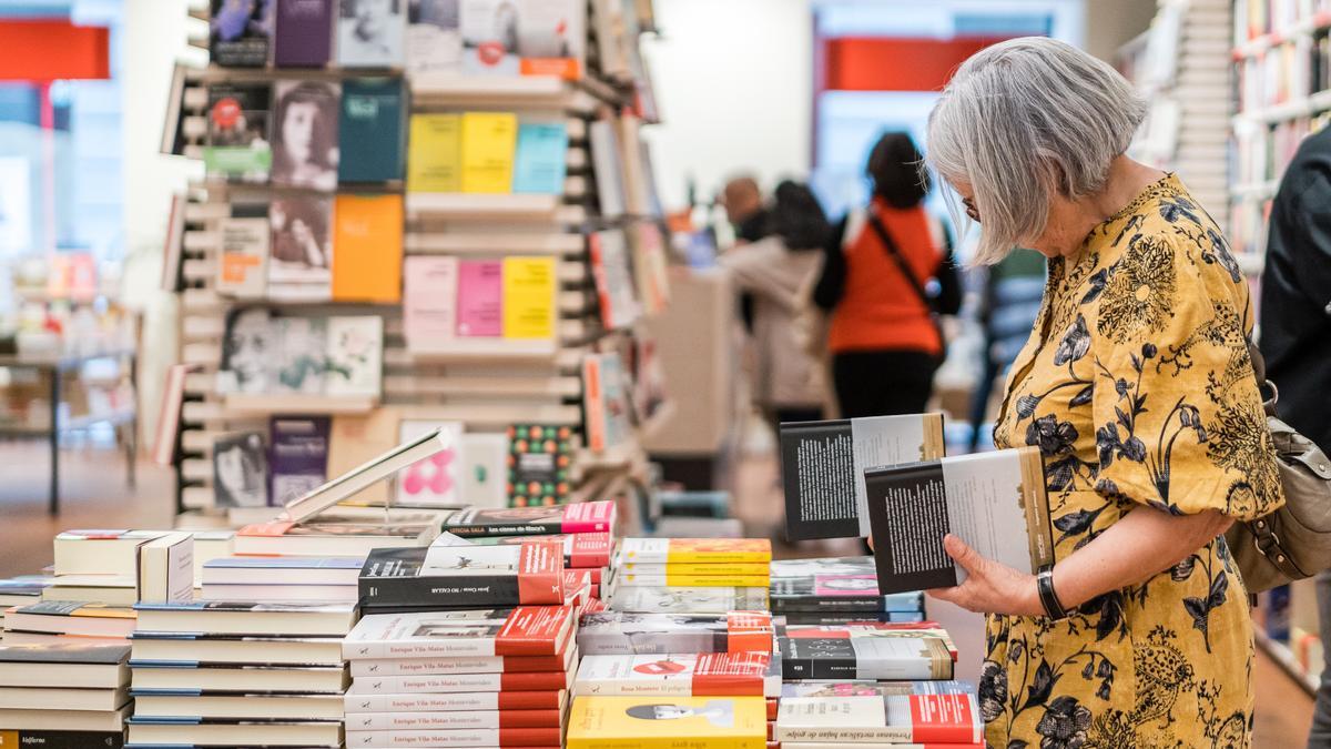 Una lectora ojea libros en en una librería