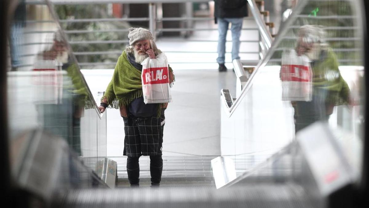 Una persona sin hogar pasea por la estación de Atocha.