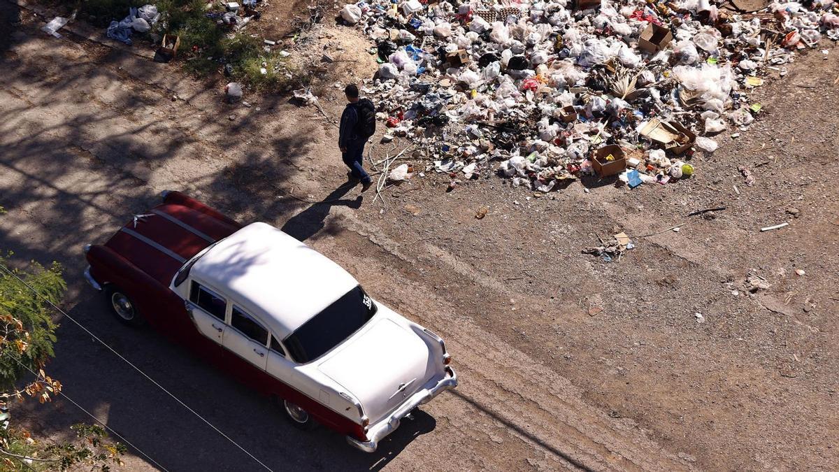 Una persona camina por una calle con basura en La Habana (Cuba).