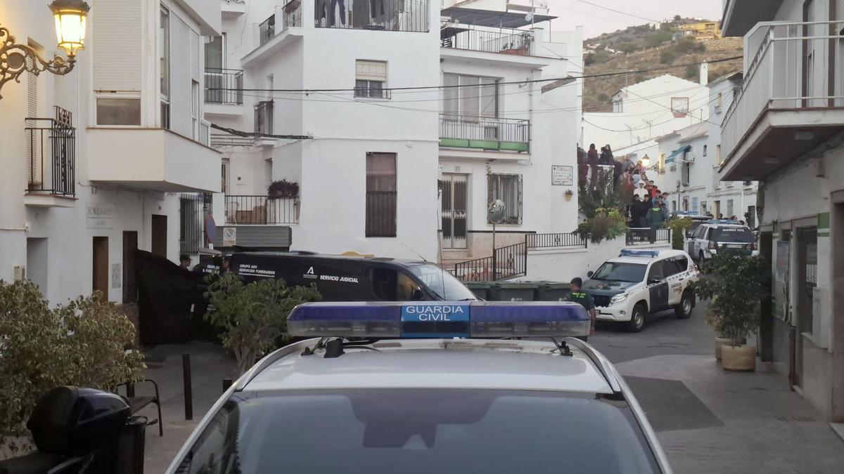 Coches de la Guardia Civil y de los servicios funerarios junto a la vivienda en Torrox (Málaga) donde han fallecido cuatro personas por un escape de gas.