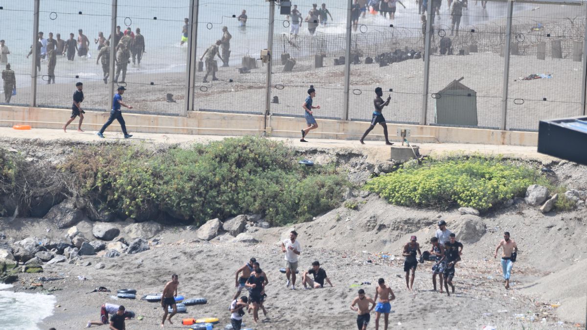 Cientos de migrantes atraviesan la frontera de El Tarajal el pasado 30 de julio.