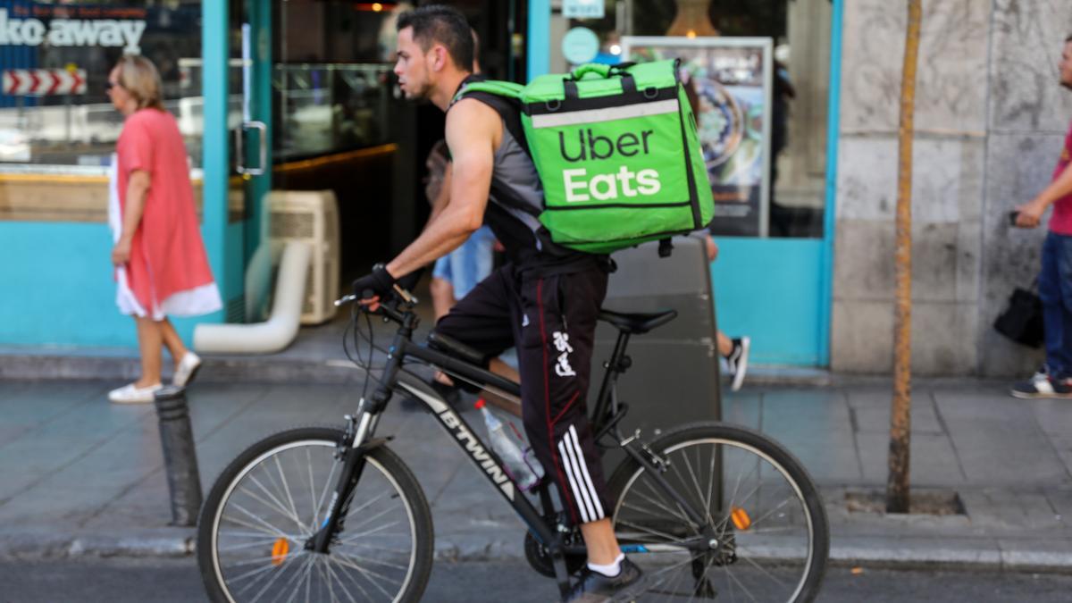 Archivo - Fotografía de un repartidor de la empresa de reparto Uber Eats transitando en bicicleta por una calle del centro de Madrid.