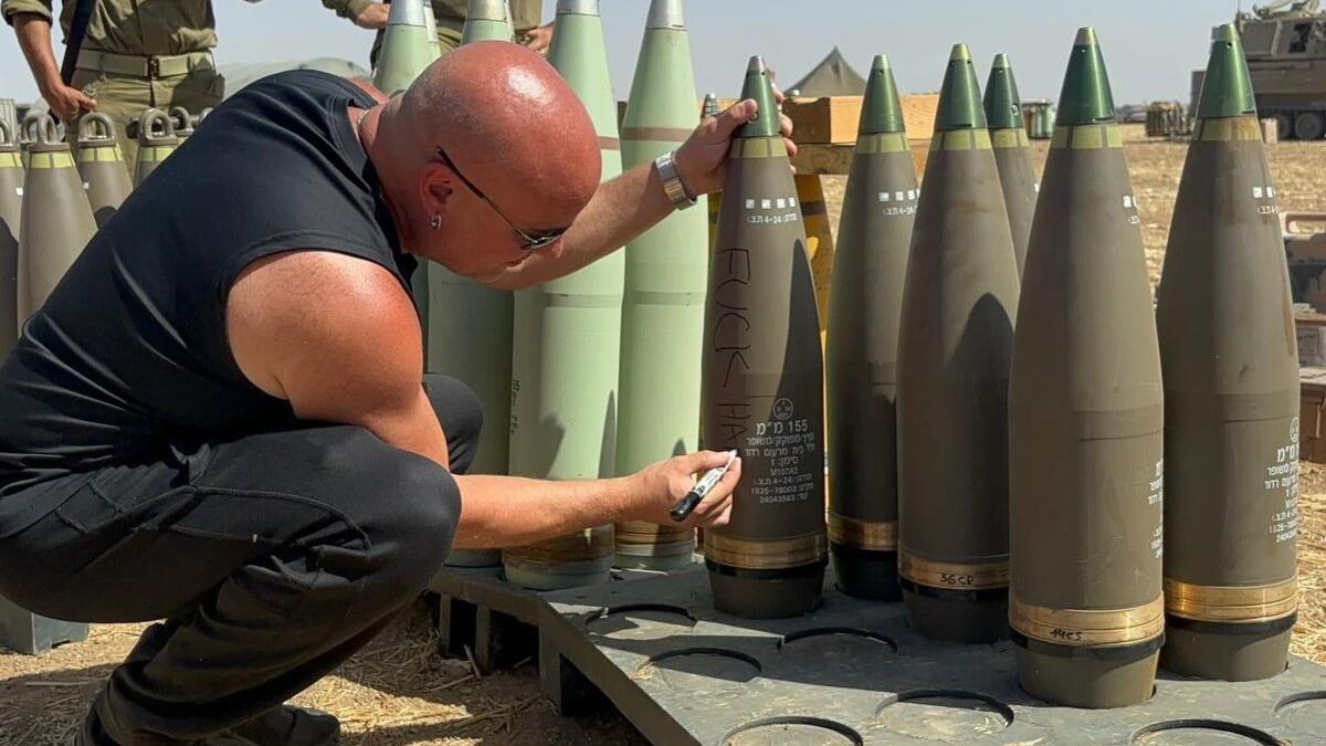 David Draiman, cantante de Disturbed, firma un proyectil de artillería en una base militar israelí cerca de la Franja de Gaza, en junio de 2024.