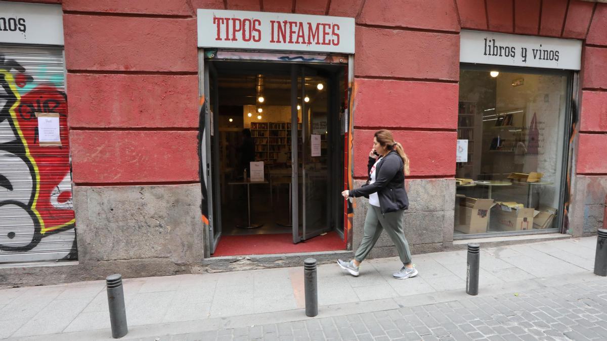 Una mujer pasa al lado de la librería Tipos Infames.