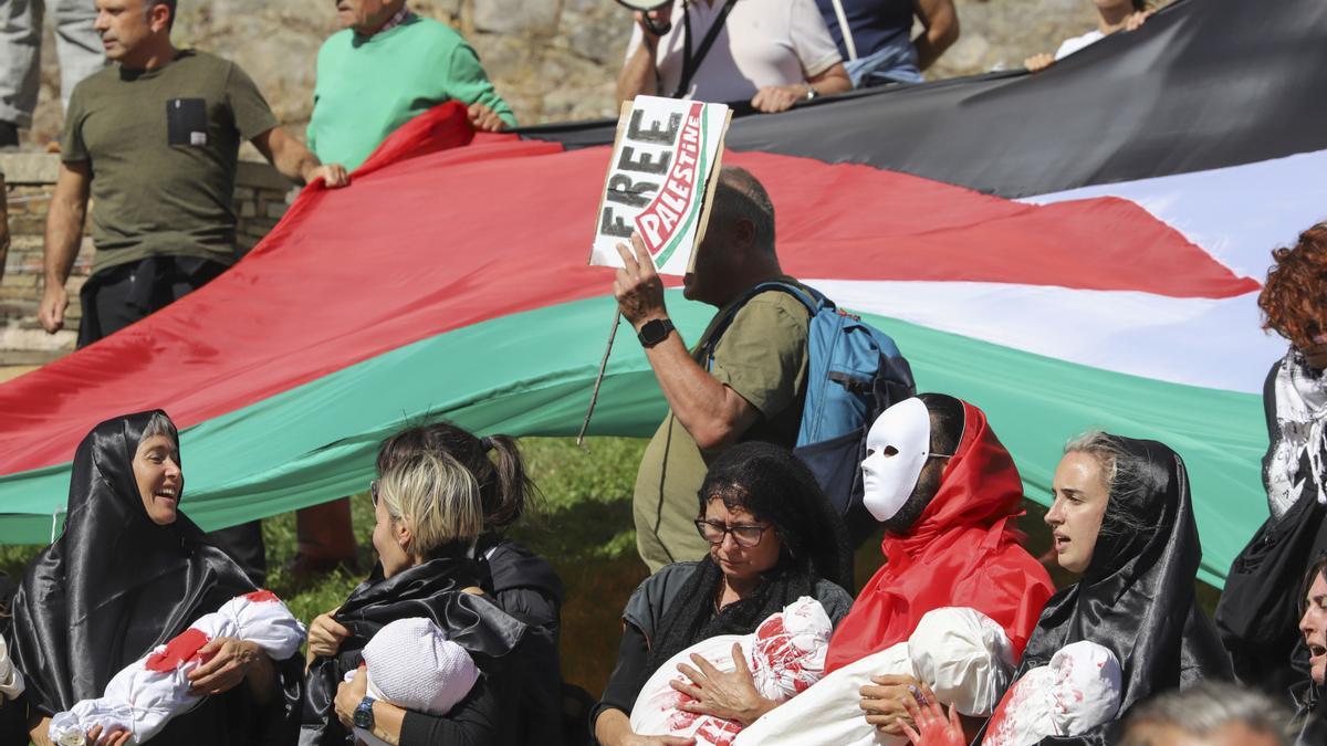 Decenas de personas protestan contra Israel al paso del pelotón por el Castillo de los Templarios en Ponferrada (León), durante la etapa 17 de la Vuelta Ciclista a España.