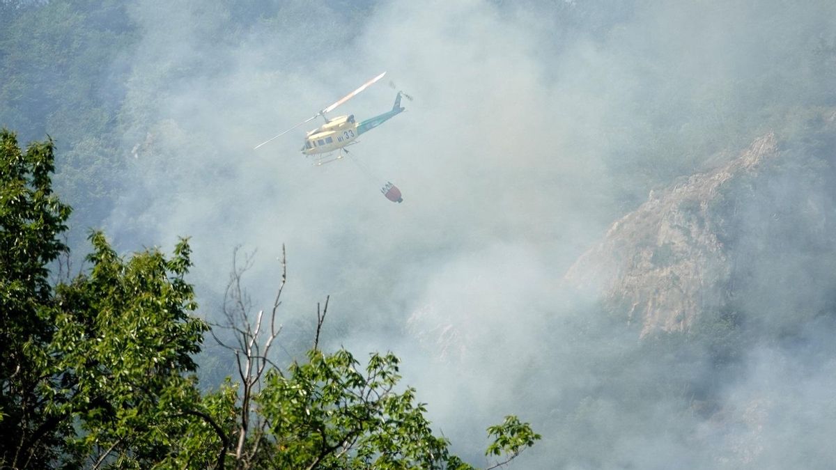 Un helicóptero ayuda en las labores para extinguir un incendio forestal, a 6 de julio de 2026, en Ribota de Sajambre, León.