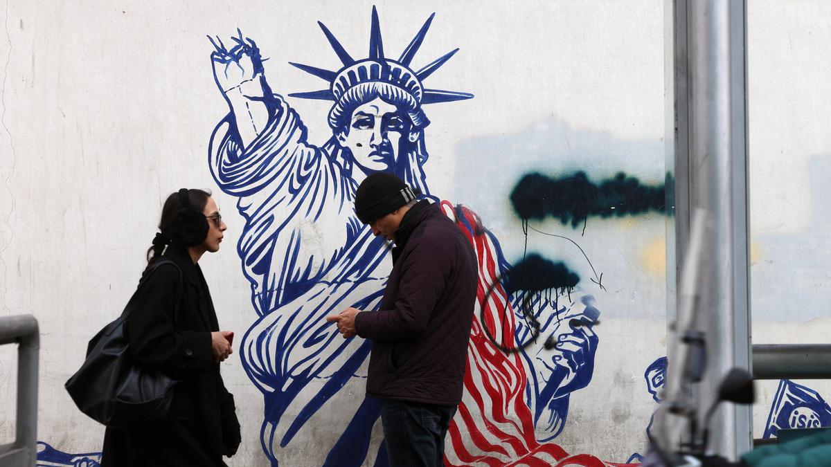 Iraníes caminan junto a un mural antiestadounidense en una calle de Teherán, Irán, el 24 de enero de 2026.