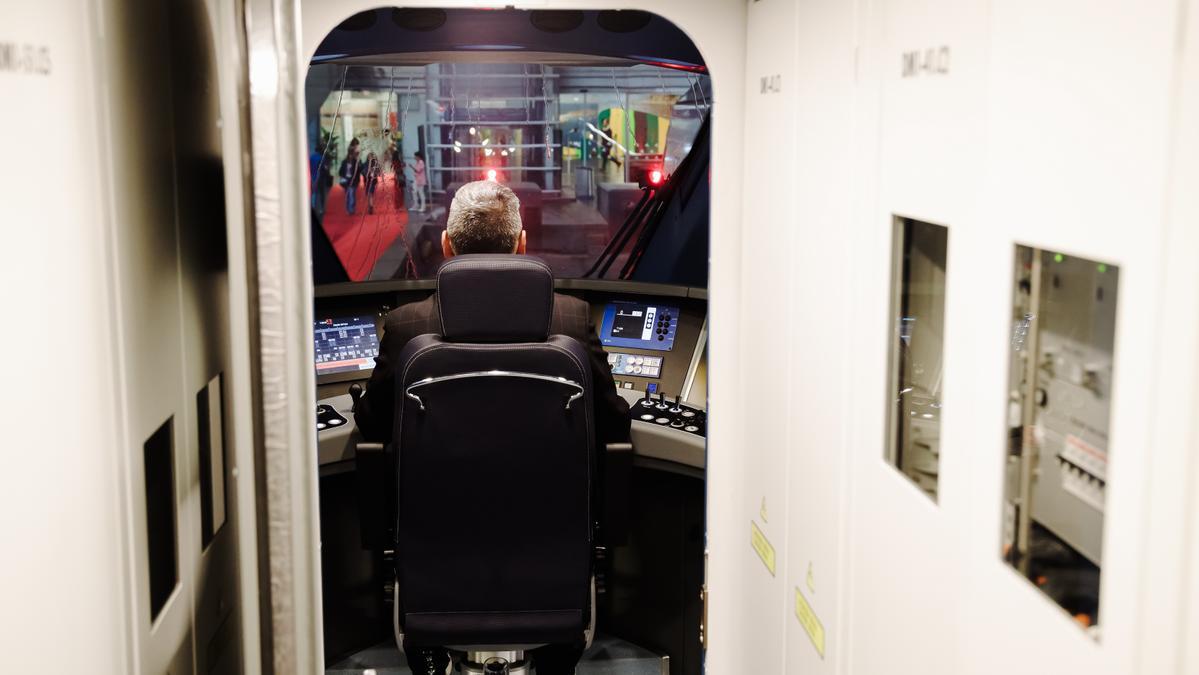 Maquinista maneja el pupitre de conducción de una locomotora.