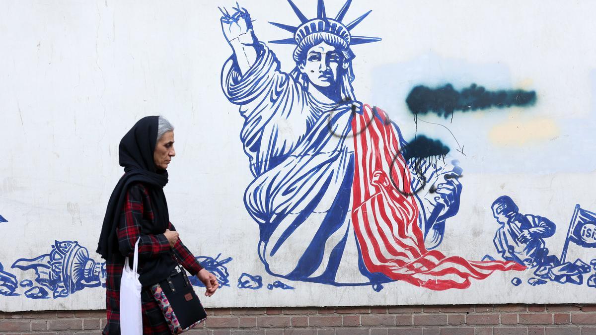 Una mujer iraní camina junto a un mural antiestadounidense en Teherán, Irán, el 23 de febrero de 2026.