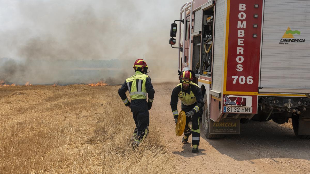 Varios bomberos trabajan para extinguir un incendio.