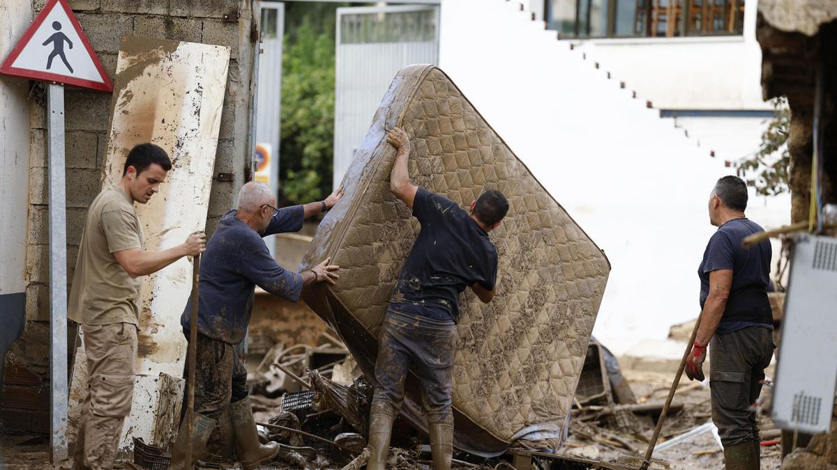 Vecinos sacan a la calle enseres dañados por las inundaciones en la localidad malagueña de Benamargosa, en una foto de archivo de 2024.