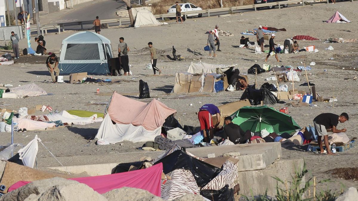 Varios migrantes permanecen este lunes acampados en la playa de El Trampolín de Ceuta.