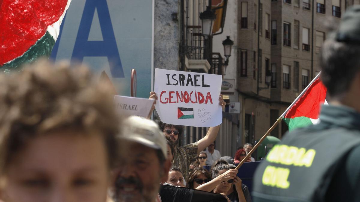 Decenas de personas con banderas de Palestina condenan el genocidio en Gaza durante la etapa 13 de la Vuelta Ciclista a España 2025.