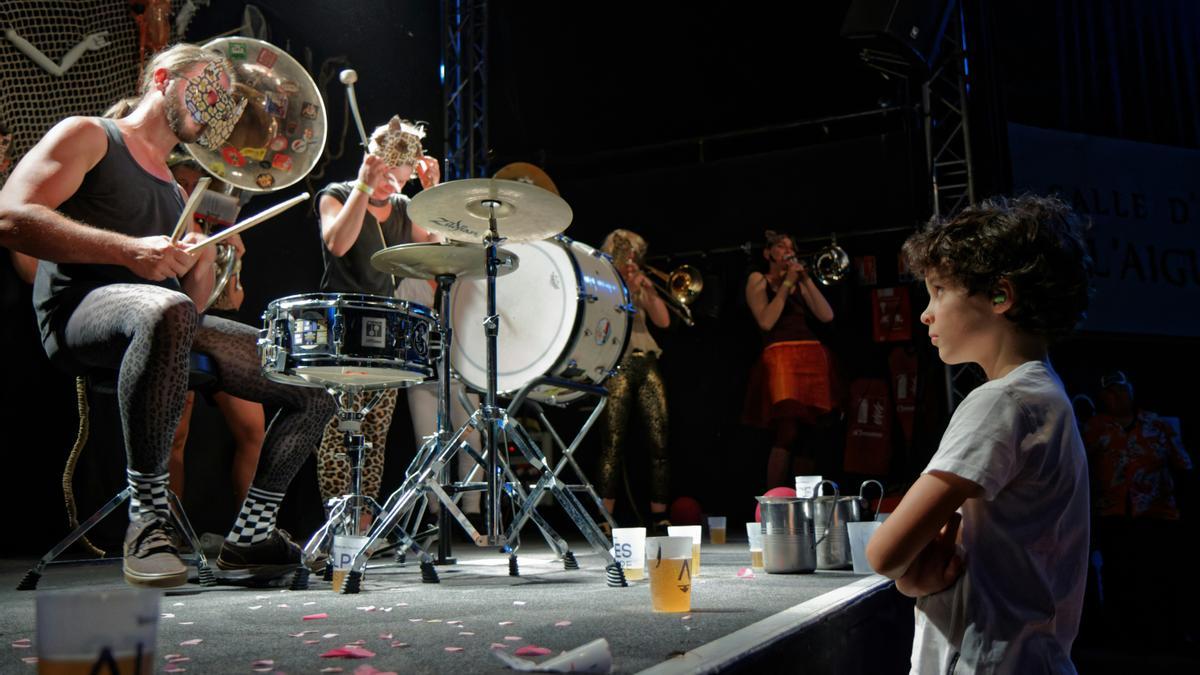 Un niño disfruta de un concierto en primera fila en una sala.