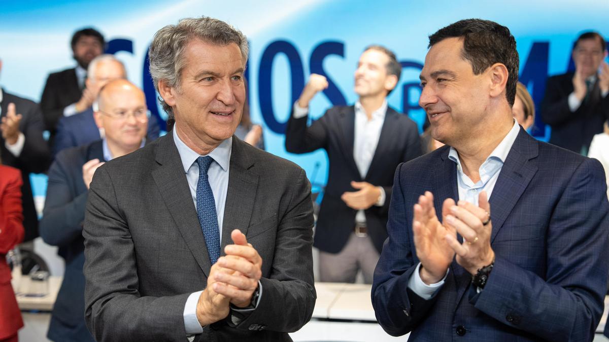 El presidente del PP, Alberto Núñez Feijóo (i) saluda al presidente de la Junta de Andalucía, Juanma Moreno (d) candidato del PP a la reelección, a su llegada a la sede del PP en Madrid