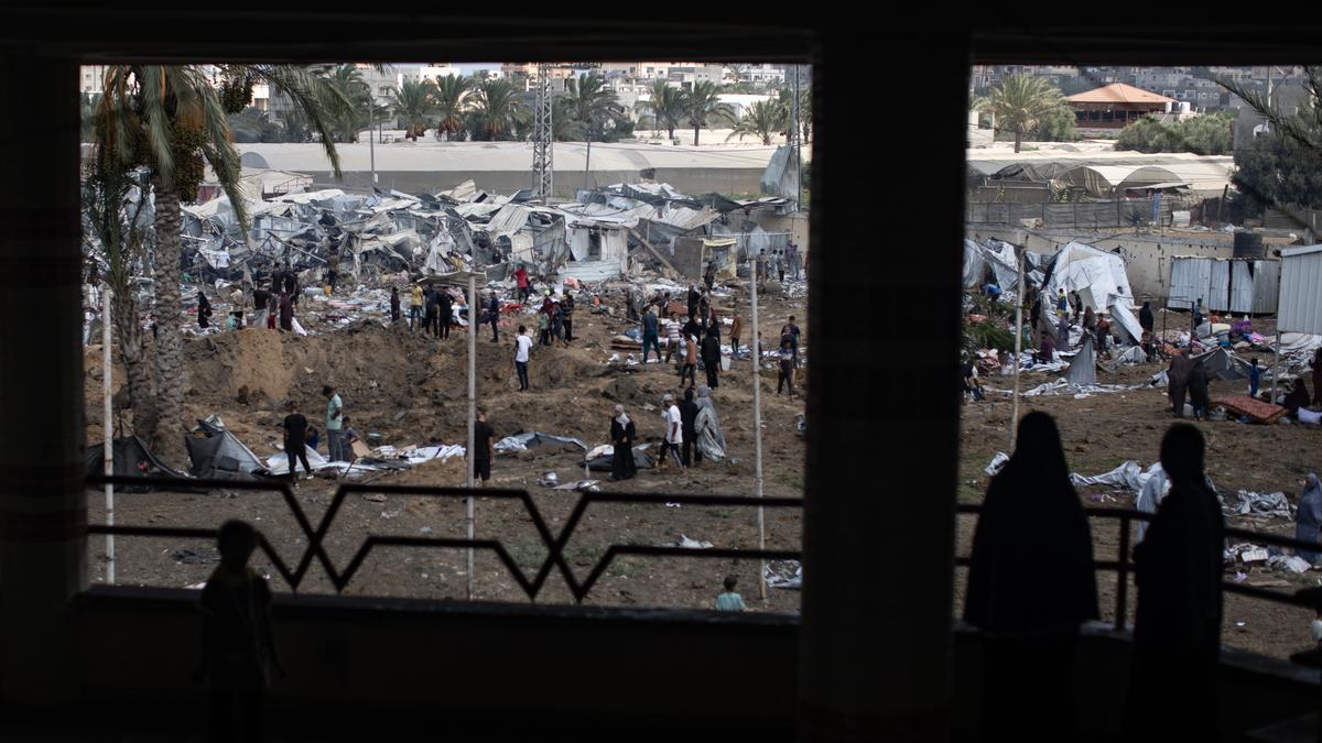 Palestinos inspeccionan las tiendas de campaña destruidas tras un ataque israelí contra el campamento de Al-Manasrah.