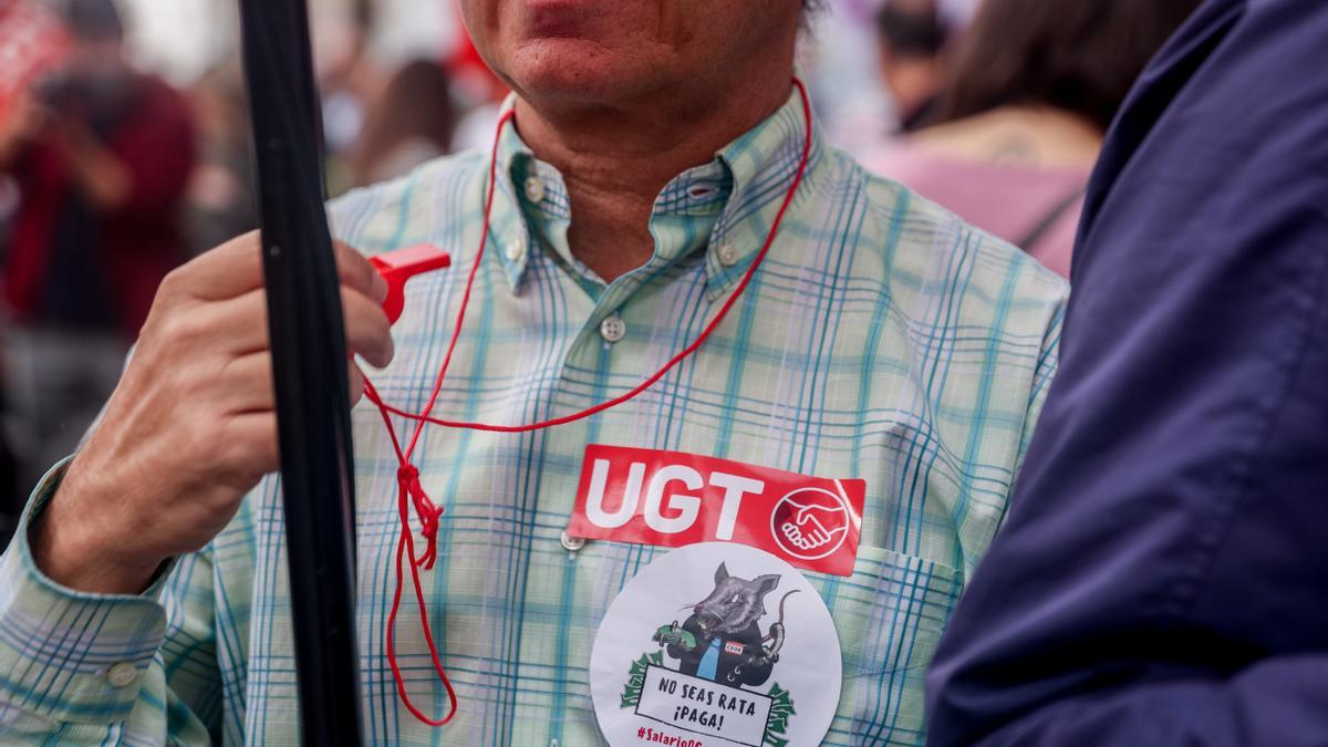Un empleado del sector financiero con pegatinas de la UGT durante una manifestación.