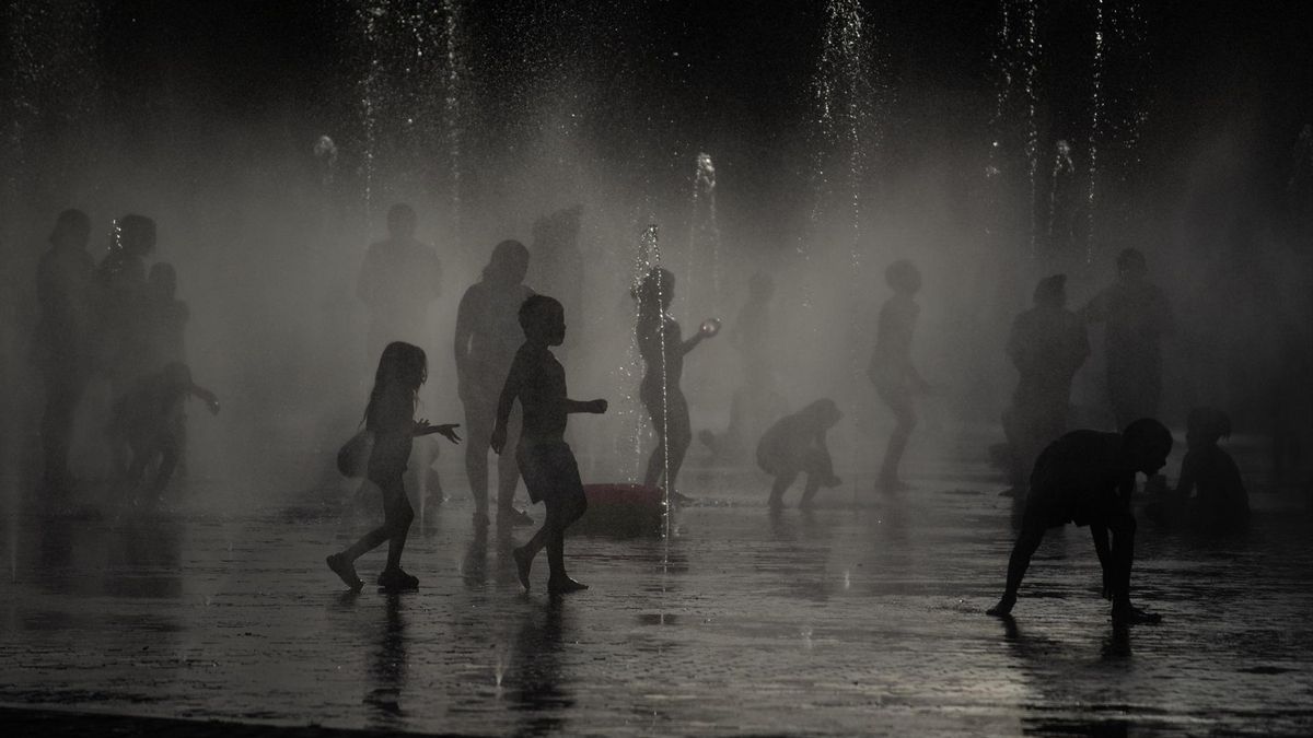 Varias personas se refrescan en las fuentes de Madrid Río, a 23 de junio de 2026, en Madrid (España).