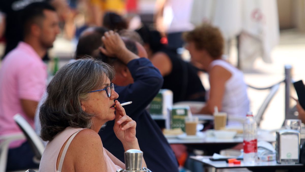 Archivo - Personas fumando en una terraza.