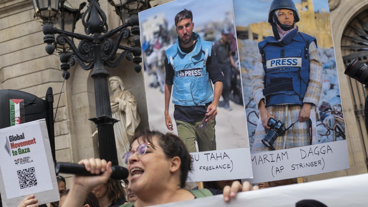 Varias personas durante una concentración contra el “asesinato sistemático” de periodistas en Gaza, en la plaza Sant Jaume.