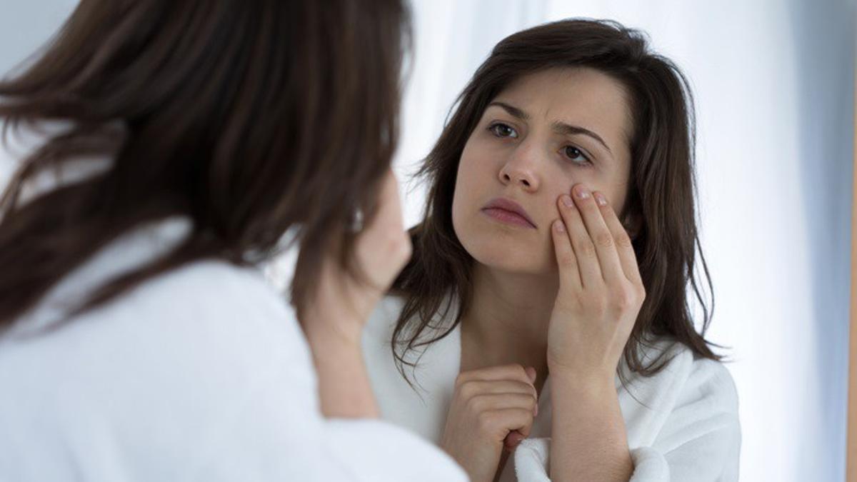 Archivo - Una mujer se mira en un espejo.