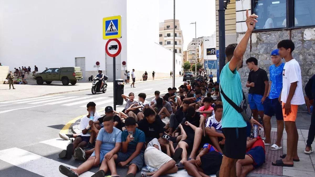 Un grupo de menores fuera de una comisaría de la Policía Nacional en Ceuta.